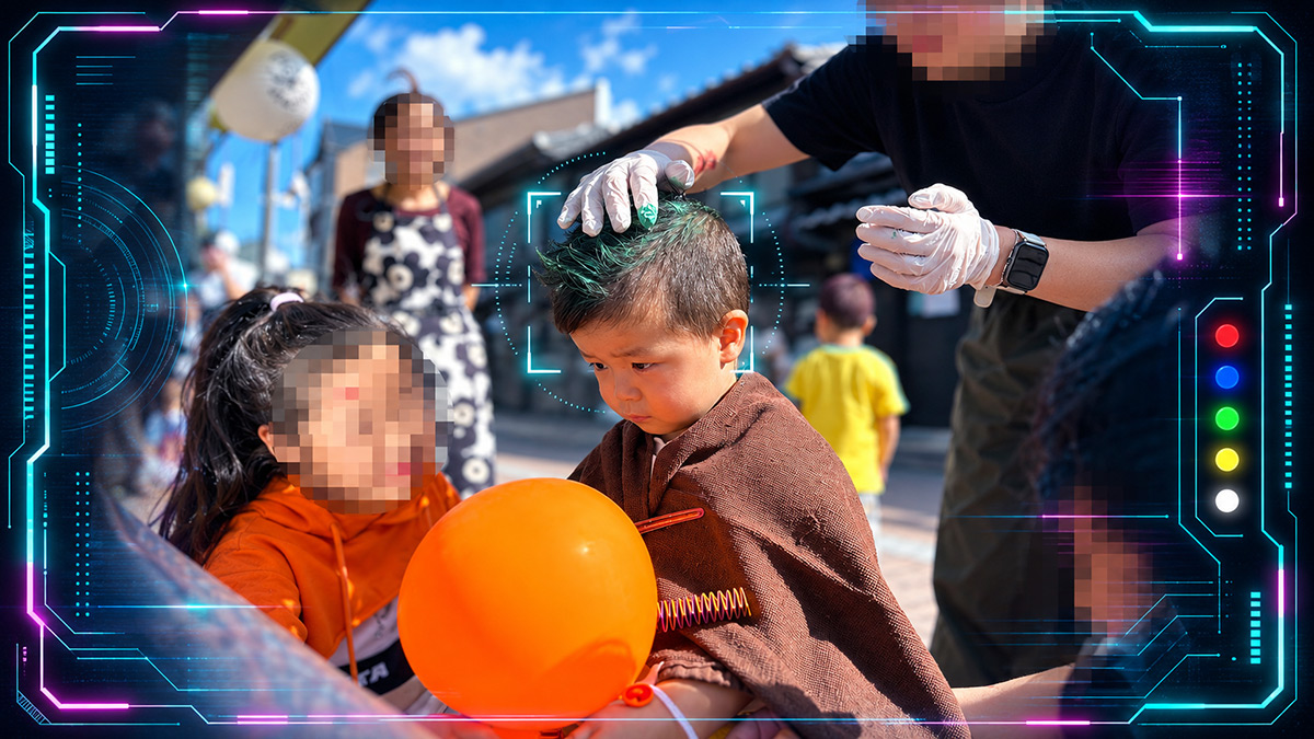 ワンデーカラーで髪を緑色にセットしてもらう子どもと、隣から様子をのぞき込む子ども